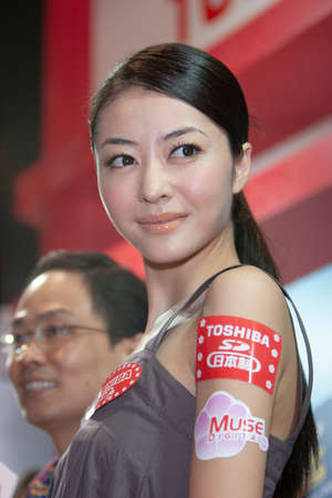 young hostesses stand next to products at the exhibition. 25 Aug 2007のeditorial素材