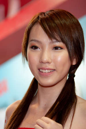 young hostesses stand next to products at the exhibition. 25 Aug 2007のeditorial素材