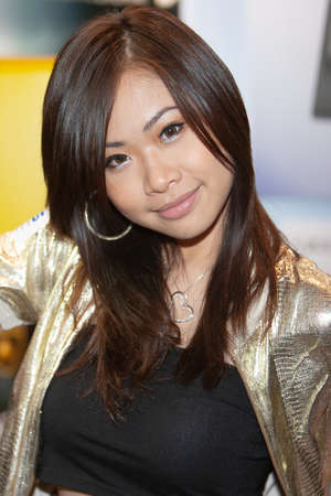 young hostesses stand next to products at the exhibition. 25 Aug 2007のeditorial素材