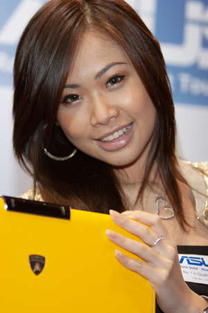 young hostesses stand next to products at the exhibition. 25 Aug 2007のeditorial素材