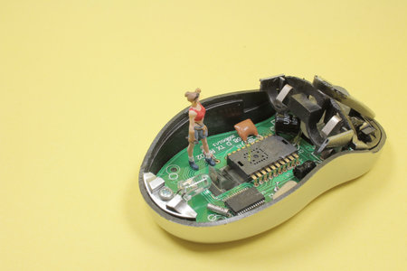 The computer mouse cracked isolated with the engineer figureの写真素材