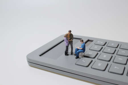 the mini doctor sits on a calculator, Health care costの写真素材