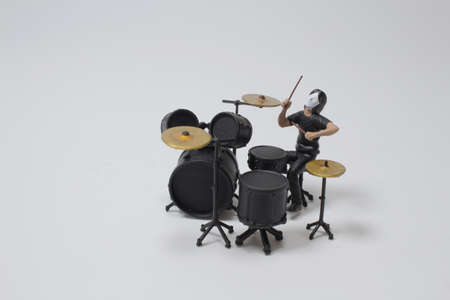 mini figure of caucasian man practice playing on drums before concer