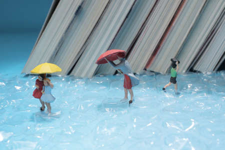 a mini figure walk ubder the rain with umbrellaの写真素材