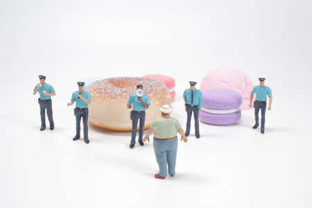 police officer stops a fat man from reaching the Dessert