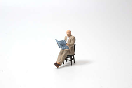 Man sitting on chair reading bookの写真素材