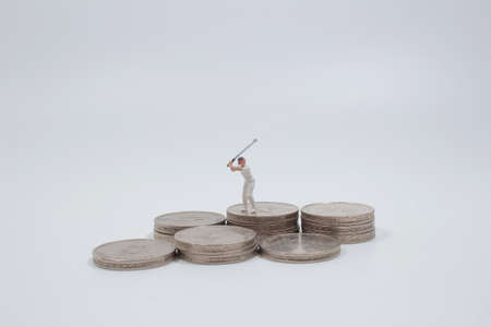 Golfers hit golf balls up to the top coins,の写真素材