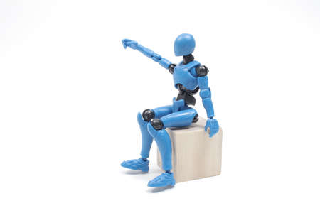 the figure is sitting with wooden block toy
