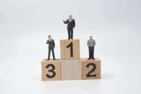 mini businessmen stand on number 1, 2 and 3 woodenの写真素材