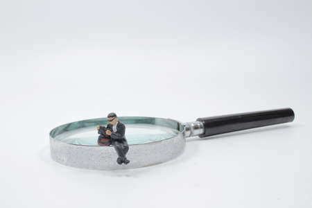 Businessman use magnifying glass to find the route on the mazeの写真素材