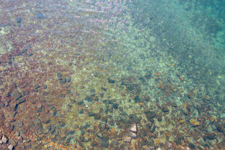 23 April 2022 boat anchored to some rocks bathed by a crystal clear,