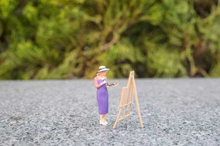 the mini of figure at woman painting in the parkの写真素材