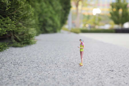 Happy sports woman with smartphone at park