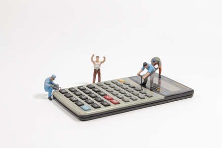 the mini figure worker men on a calculatorの写真素材
