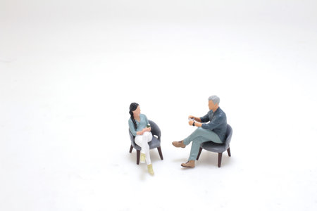 journalist in suit talking with businessman sitting in armchair