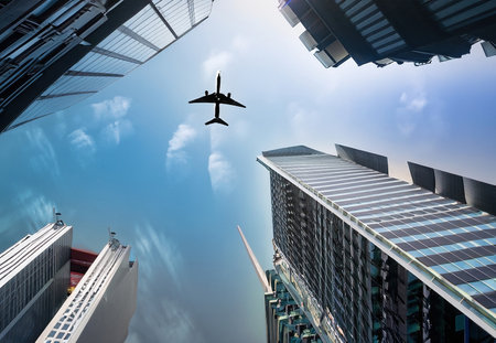 skyscrapers and airplane in sky in city 1の素材