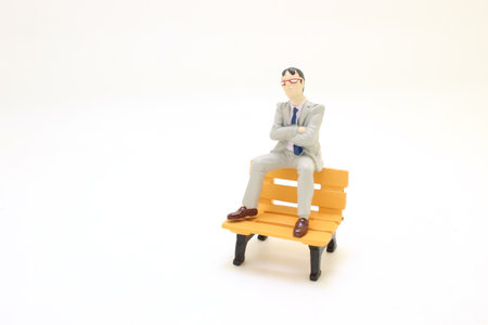 a figure businessman sitting on park benchの写真素材