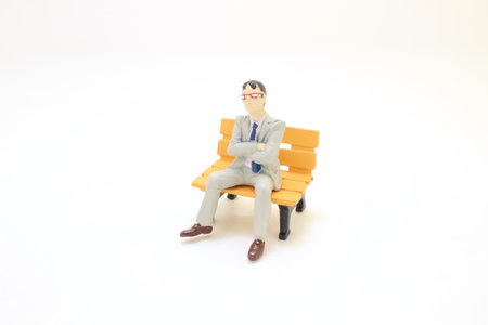a figure businessman sitting on park benchの写真素材