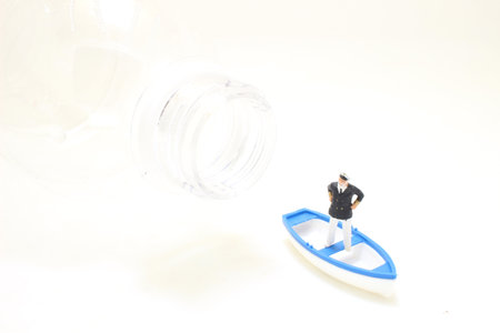 the small boat with the tiny figure captainの写真素材