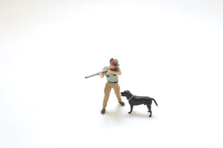 miniature figurine features a hunter holding a rifle accompanied by a black dog, set against a plain