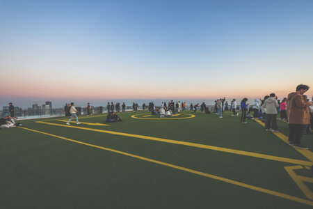Dec 4 2024 gathering on a rooftop helipad, enjoying the cityscape and sunset,