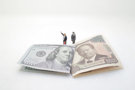 positioned between a US dollar bill and a Japanese yen banknote,の写真素材