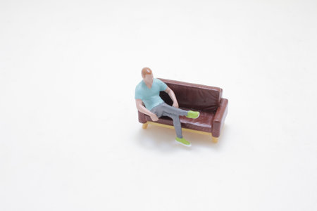 figurine of a casual person seated on a brown sofa,の写真素材