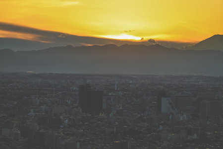 Beautiful scenery of a sunset with an urban skyline and mountainの写真素材