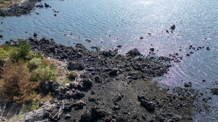March 23 2025 coastline with crystal-clear water, rocky shore, and a walking path amidst nature.の写真素材