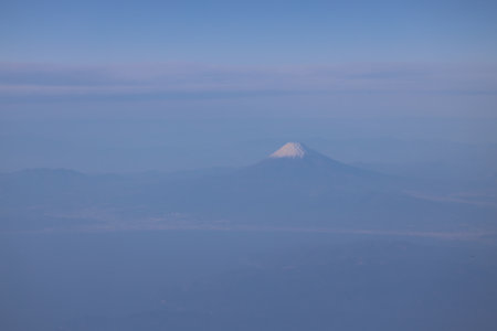 view showcases a magnificent mountain capped with snow surrounded by a clear blue atmosphere