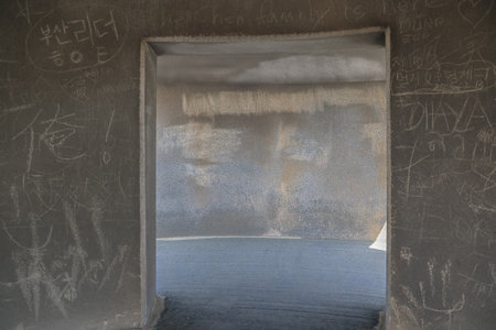 photograph of a tunnel entrance in an urban setting, with walls marked with graffiti. The dim lighting createsの写真素材