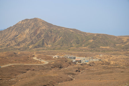 Arid desert scene featuring small remote huts, a clear blue skyの写真素材