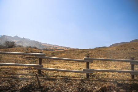 A scenic view of a rural landscape with a wooden fence iの写真素材