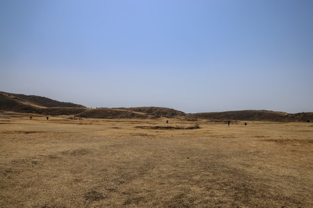 Vast dry plains stretching toward rolling hills under a bright,の写真素材