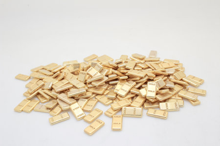 A collection of gold bullion bars stacked together, illustrating wealth