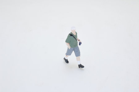 A miniature figure of a person holding a camera, dressed casually,