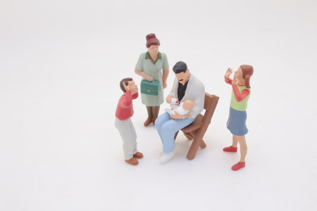 miniature toy figures representing a family gathering to see a baby