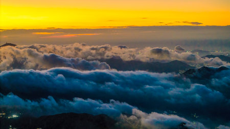 captivating view of a vibrant sunrise illuminating mountains and cloudの写真素材
