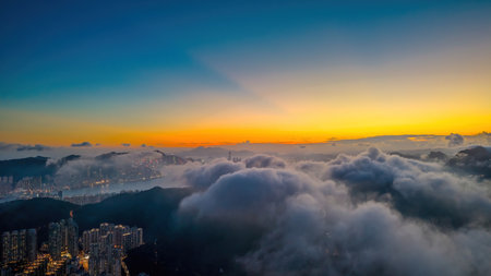 breathtaking view showing a city skyline under a glowing sunset with cloudsの写真素材