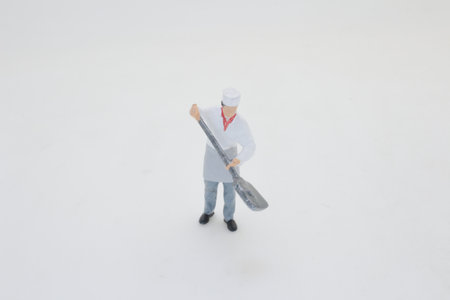 A small model of a chef standing on a white background, holdingの写真素材