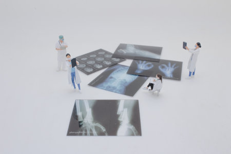 Professionally dressed miniature figures of medical professionals examiningの写真素材