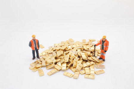 representing laborers standing beside a heap of shiny goldの写真素材