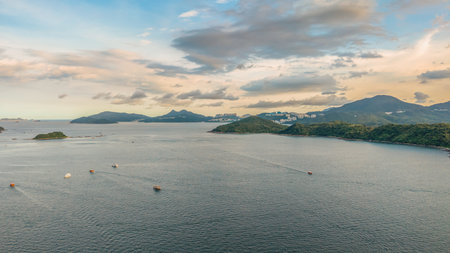 landscape featuring a tranquil bay surrounded by green hills under a cloudy