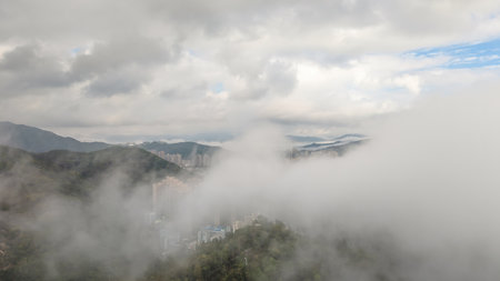 March 2 2025 fog envelops a mountain landscape, obscuring a cityの写真素材