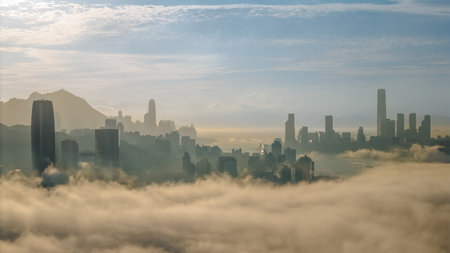 March 2 2025 skyscrapers surrounded by rolling fog with a serene mountain backdrop.