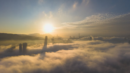 March 2 2025 skyscrapers surrounded by rolling fog with a serene mountain backdrop.