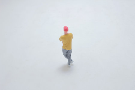 miniature figurine of a person standing on a white surface, captured in detail.