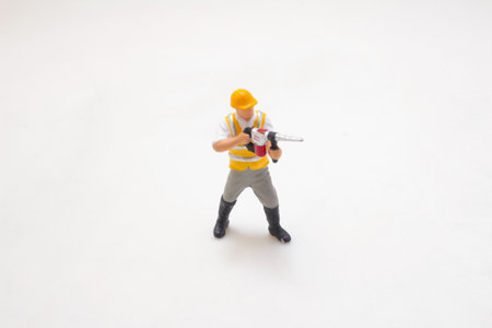 Plastic miniature figure of a construction worker equipped with a hard hat,の写真素材
