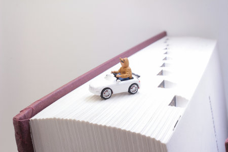 A detailed close-up of a miniature toy of a cat figurine driving a car placedの写真素材
