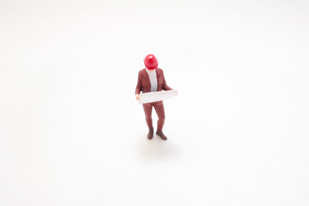 Toy-like figurine of a professional engineer wearing a red helmetの写真素材